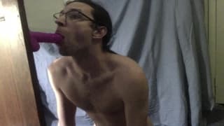 Mec à queue de cheval suce un godemiché