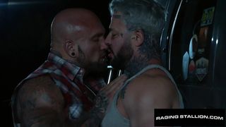 DILFs gays musclés et tatoués baisant à cru en extérieur la nuit